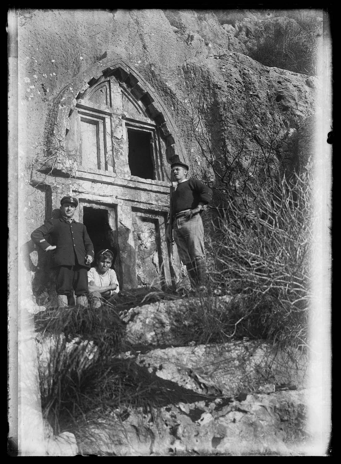 Trois personnages devant l'entrée d'une tombe rupestre